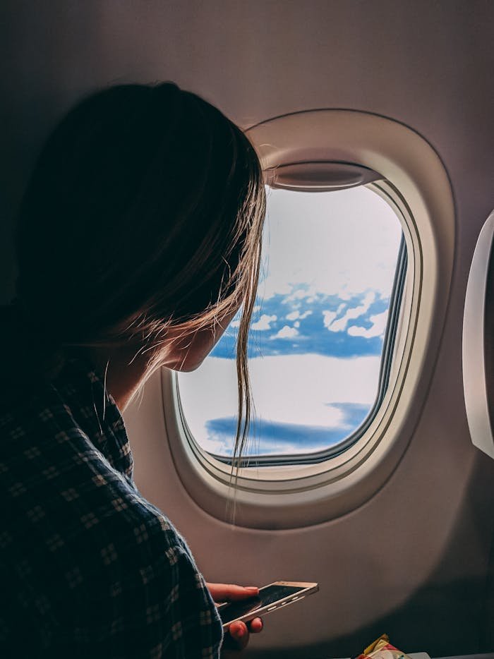 pexels-photo-2033343 Person Holding Smartphone Riding Airplane